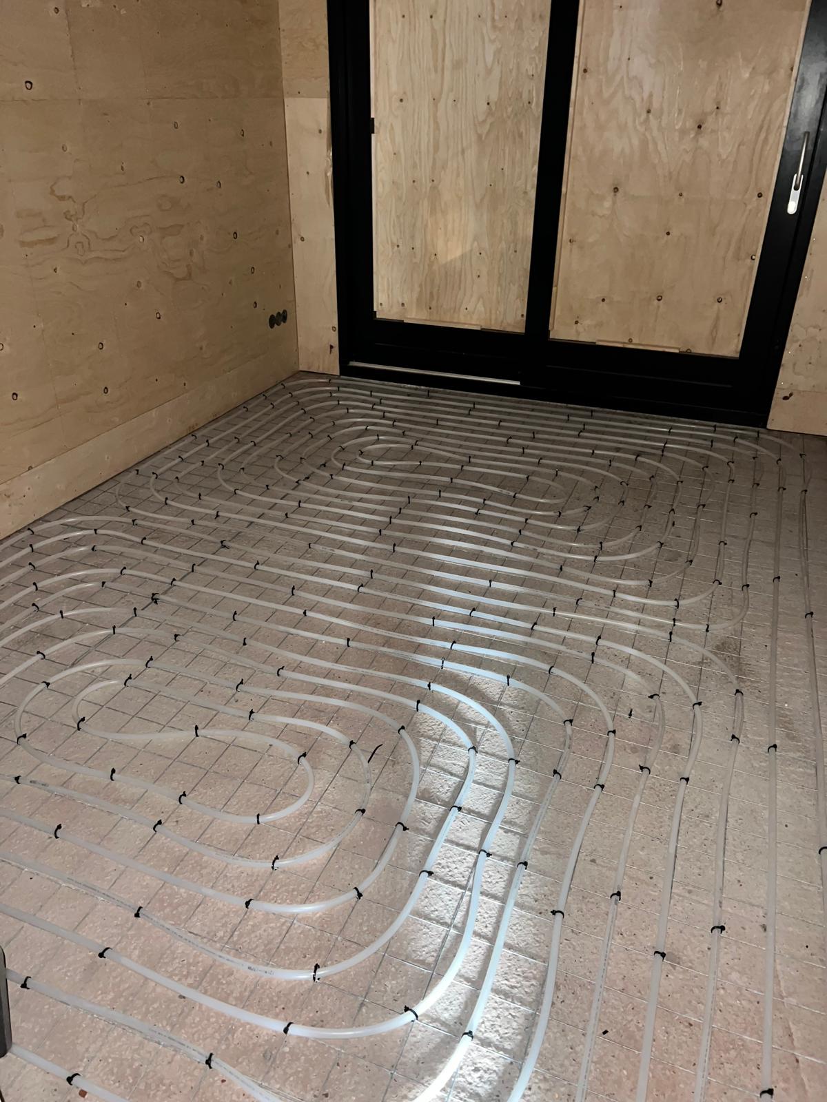 Leidingwerk voor vloerverwarming in woningrenovatie